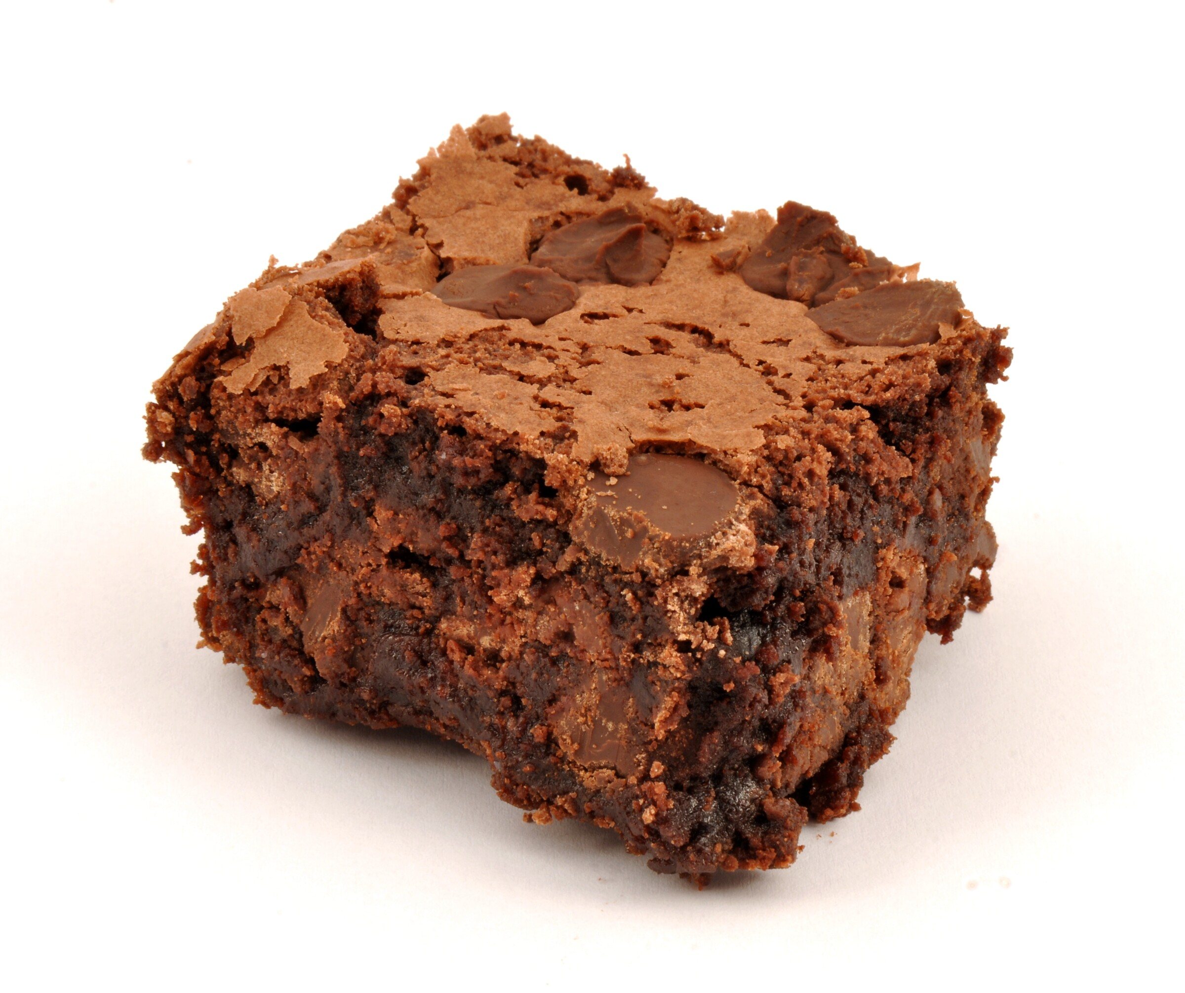 A square fudgy chocolate brownie with chocolate chunks on a white background